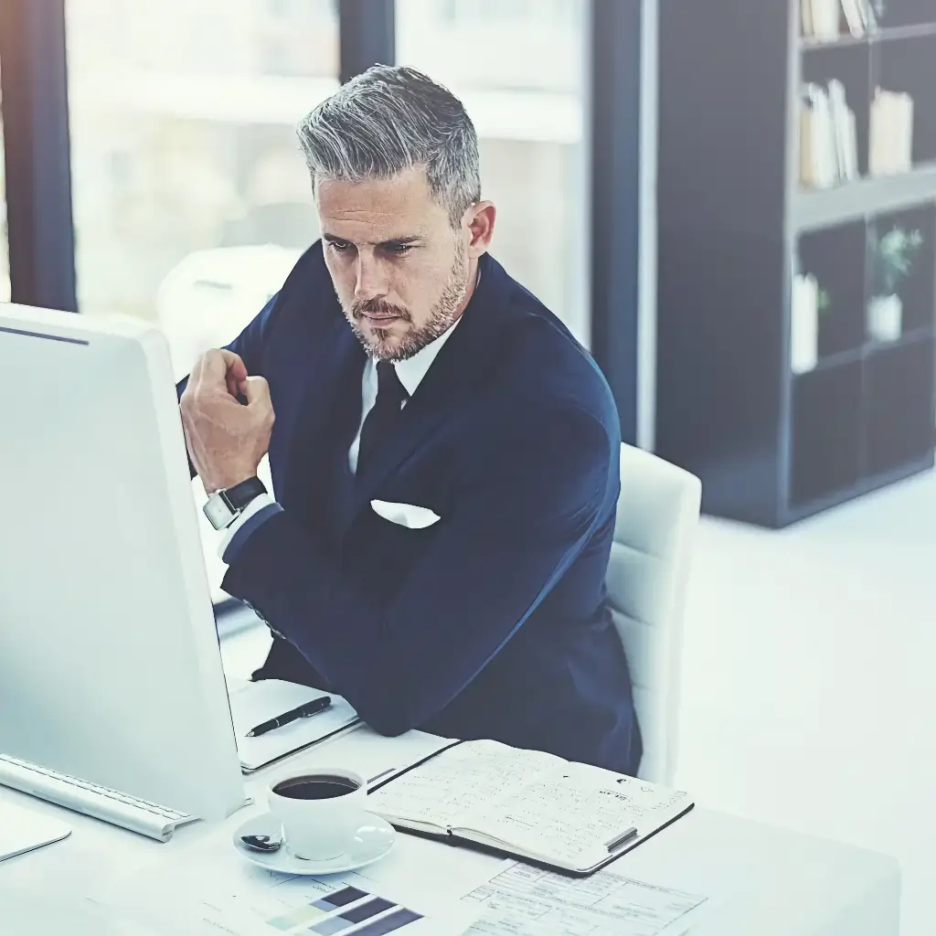 Hire a digital marketing consulting agency that is willing to fight through obstacles, displayed in this photo as a man concentrates on the task at hand, problem-solving on his computer monitor.
